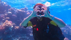Plongeuse sous-marine formant un cœur avec ses doigts
