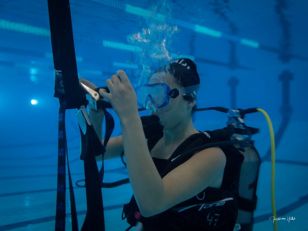 Plongeuse manœuvrant un parachute de plongée lors d’un escape game sous-marin, illustrant une activité ludique et éducative sous l’eau pour apprendre à plonger en s'amusant avec un escape game sous-marin