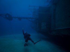Plongeur faisant le signe OK devant une épave lors d’une exploration fascinante en plongée à l’île Maurice.