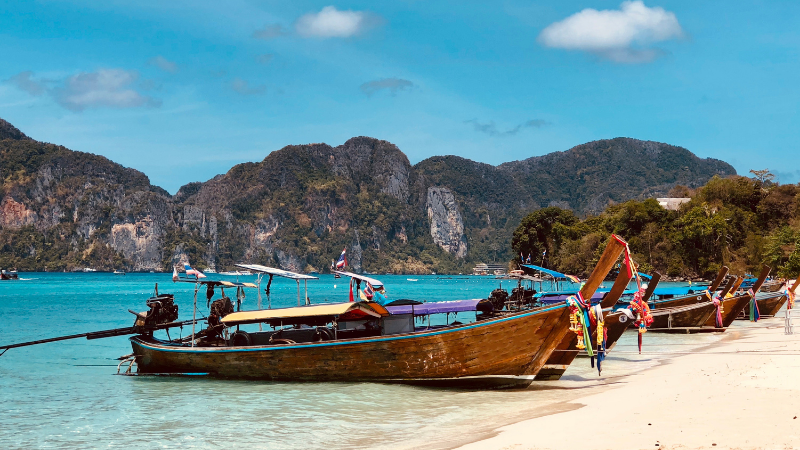 Bateaux traditionnels thaïlandais sur la plage devant les montagnes — mer d'Andaman