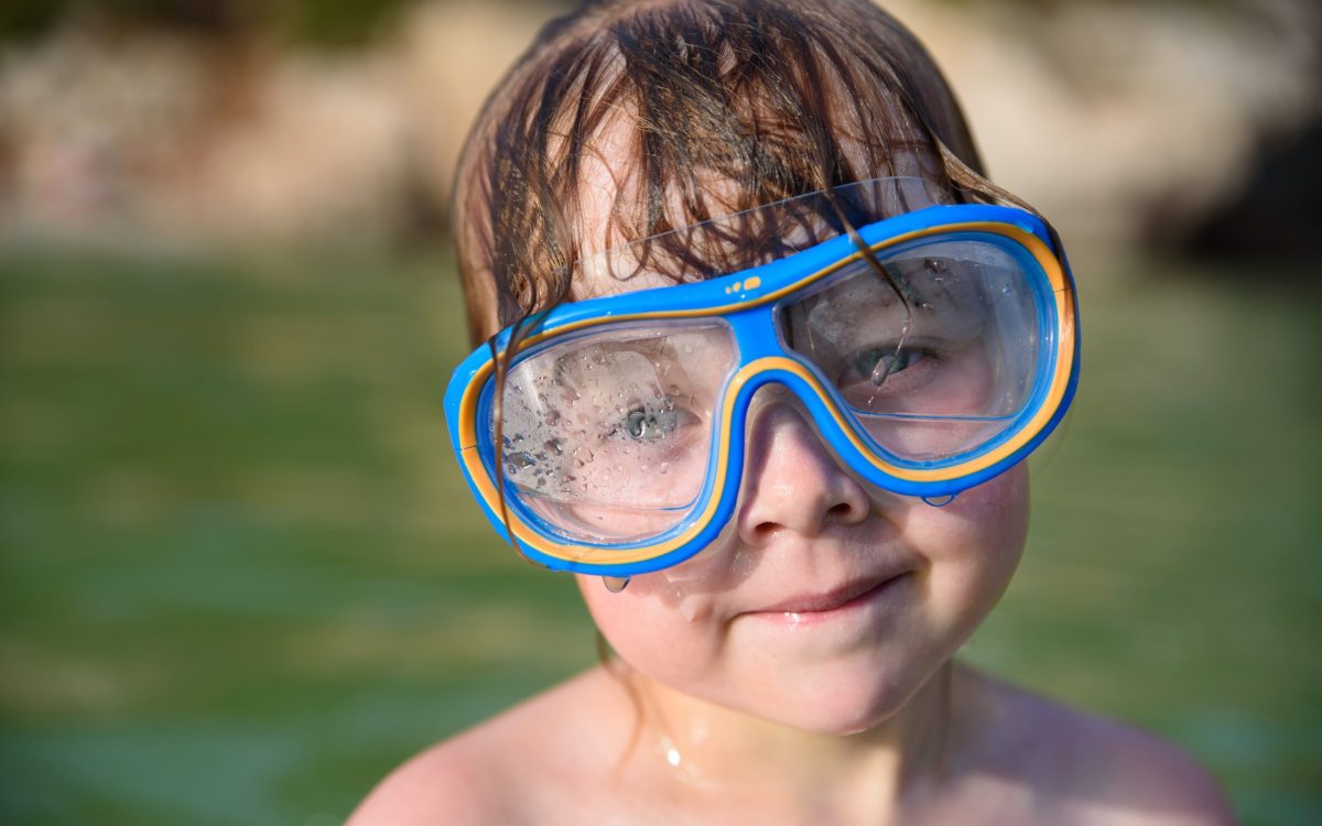 Jeunesse et découverte : Une plongeuse en herbe découvre l'effet de la buée dans son masque lors de sa première expérience sous-marine.